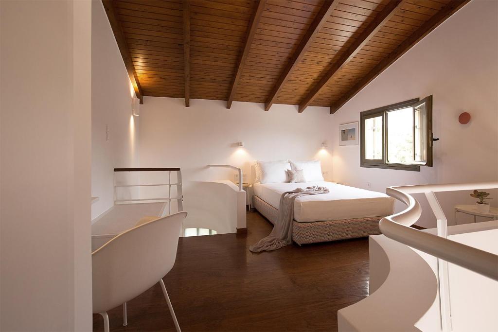 a white bedroom with a bed and a window at Villa Pefki in Chania