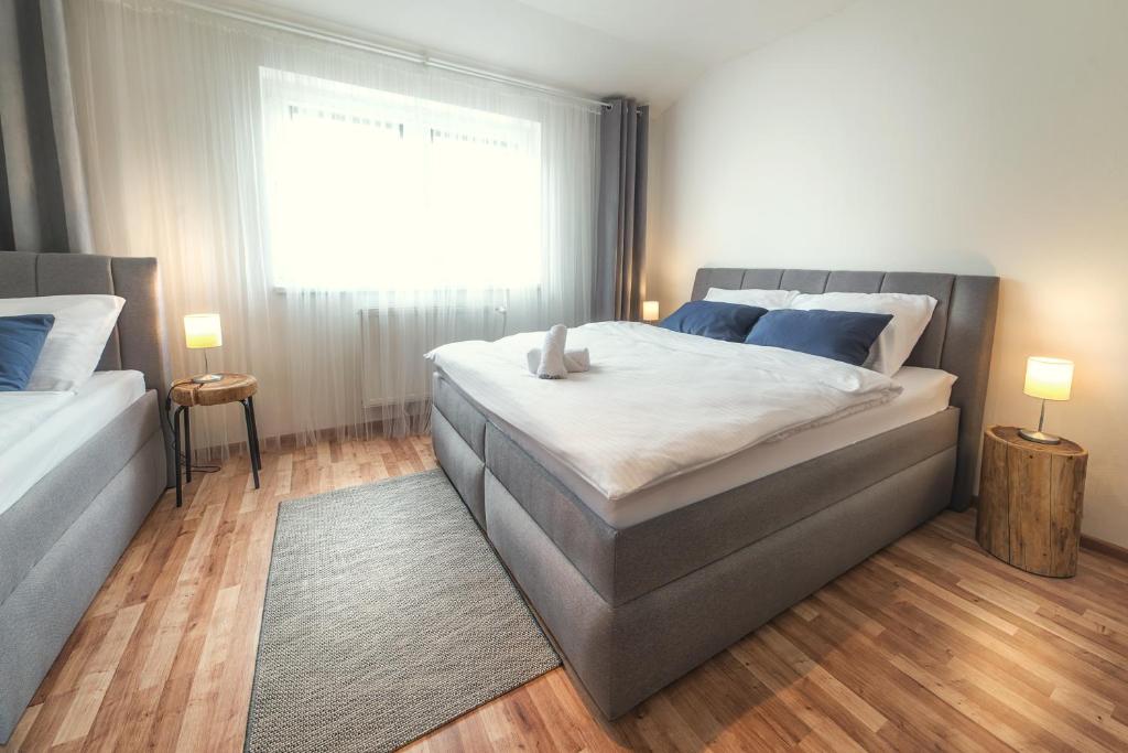 a bedroom with a large bed and a window at Apartmány MINATA in Liptovský Mikuláš