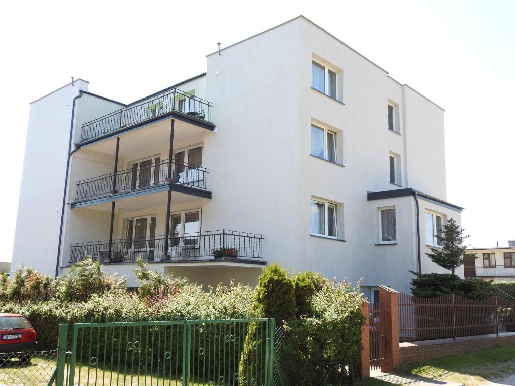 a white building with balconies and a fence at U Reginy in Jastrzębia Góra