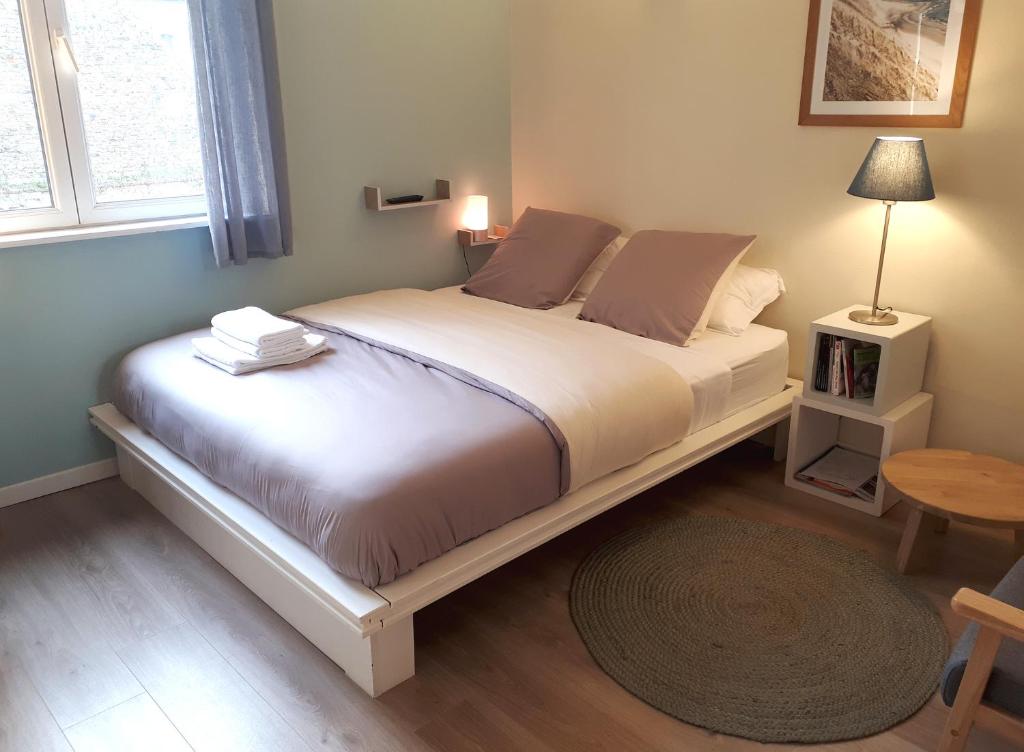 uma cama grande num quarto com uma mesa em Le Coquet em Saint-Omer