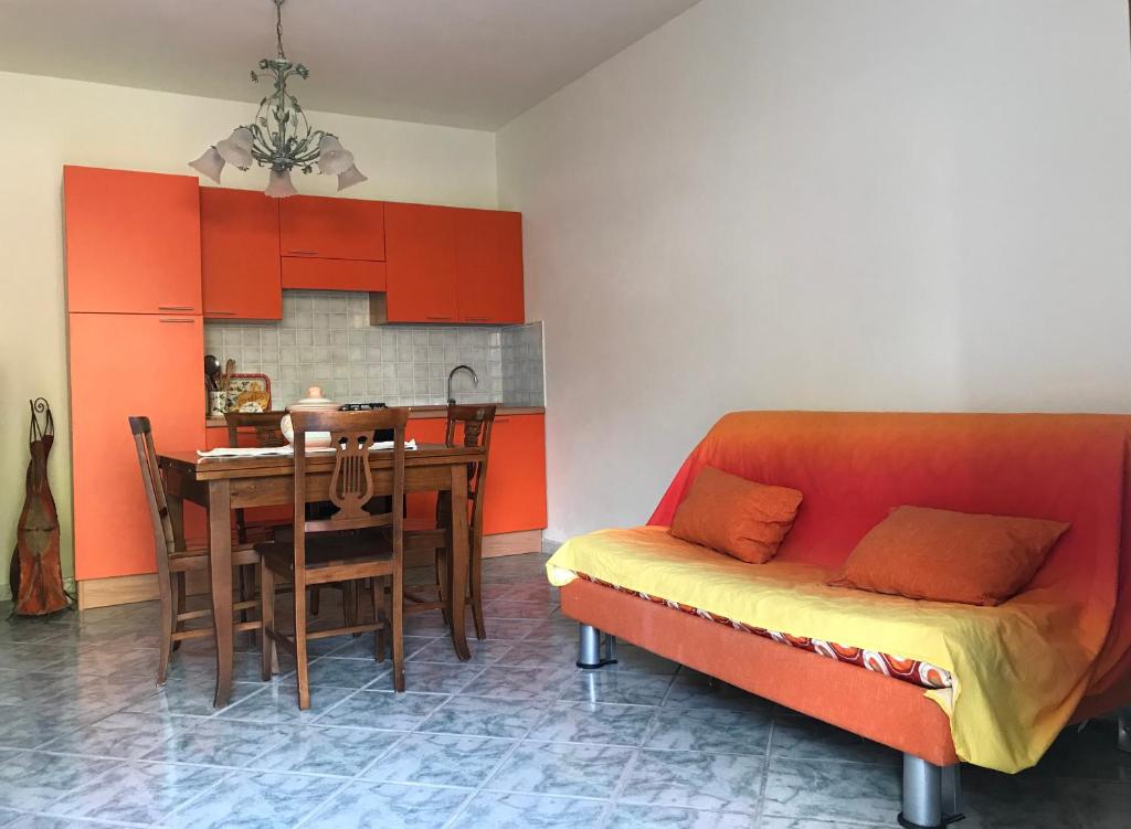 un soggiorno con divano rosso e tavolo di Appartamenti LaConia Cannigione a Cannigione