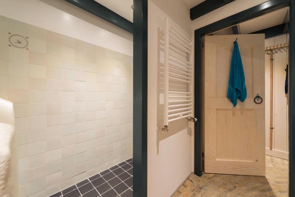 a bathroom with a walk in shower next to a door at de Boskpleats in Winsum