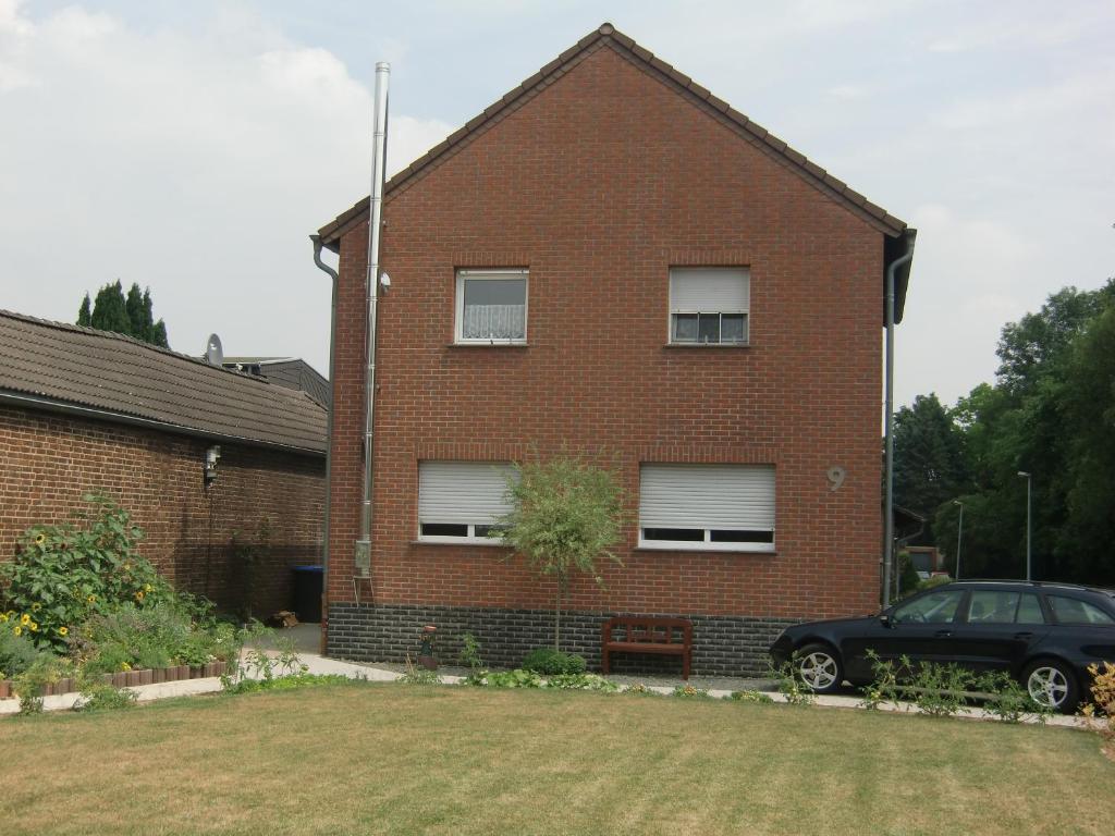 a brick house with a car parked in front of it at Domi's Gästehaus in Bergheim