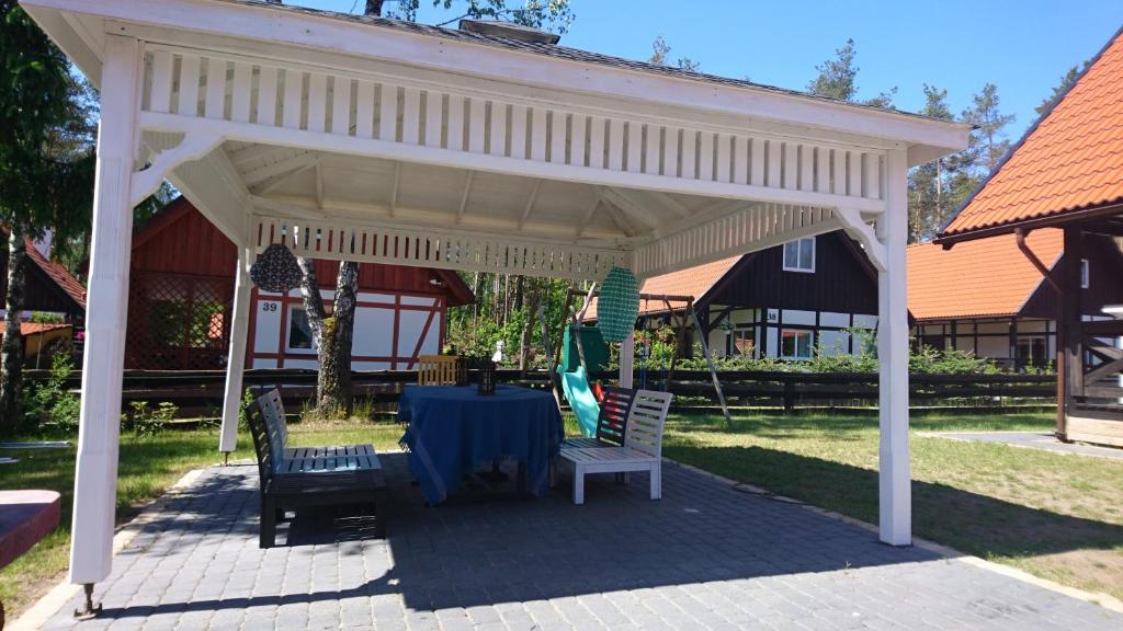 a white pavilion with a table and two chairs at Kaszubówka 22 in Załakowo