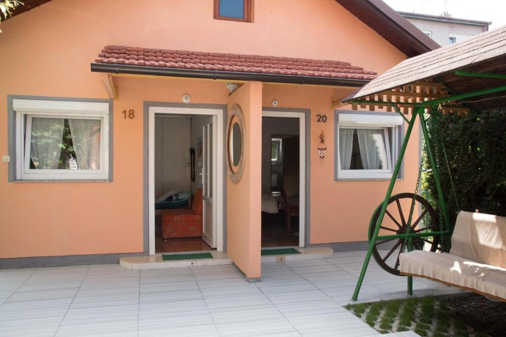 a small house with two windows and a patio at Sobe Dario in Daruvar