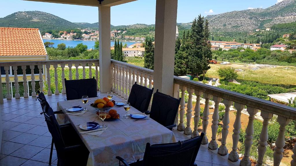 una mesa en un balcón con vistas al agua en Apartments Zvono, en Slano