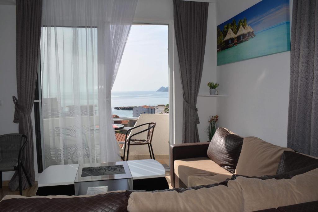 a living room with a couch and a large window at Studios Seaview in Dobra Voda