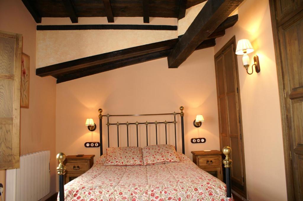 una camera con letto in una stanza con travi a vista di La Cuestecilla a Hervás