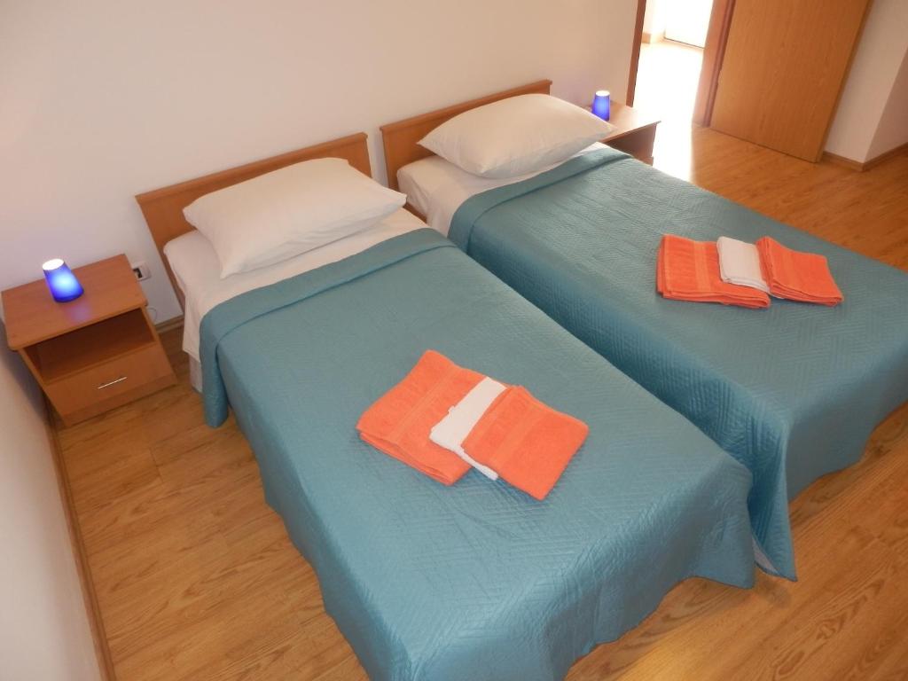 two beds in a room with orange and white pillows at Apartment Greta in Kanfanar