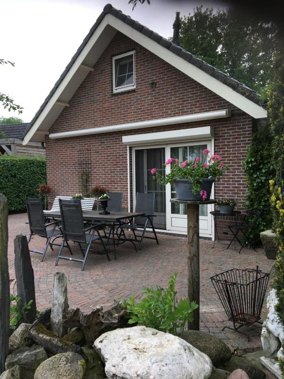 Cette maison dispose d'une terrasse avec une table et des chaises. dans l'établissement Carpe Diem Nijverdal, à Nijverdal