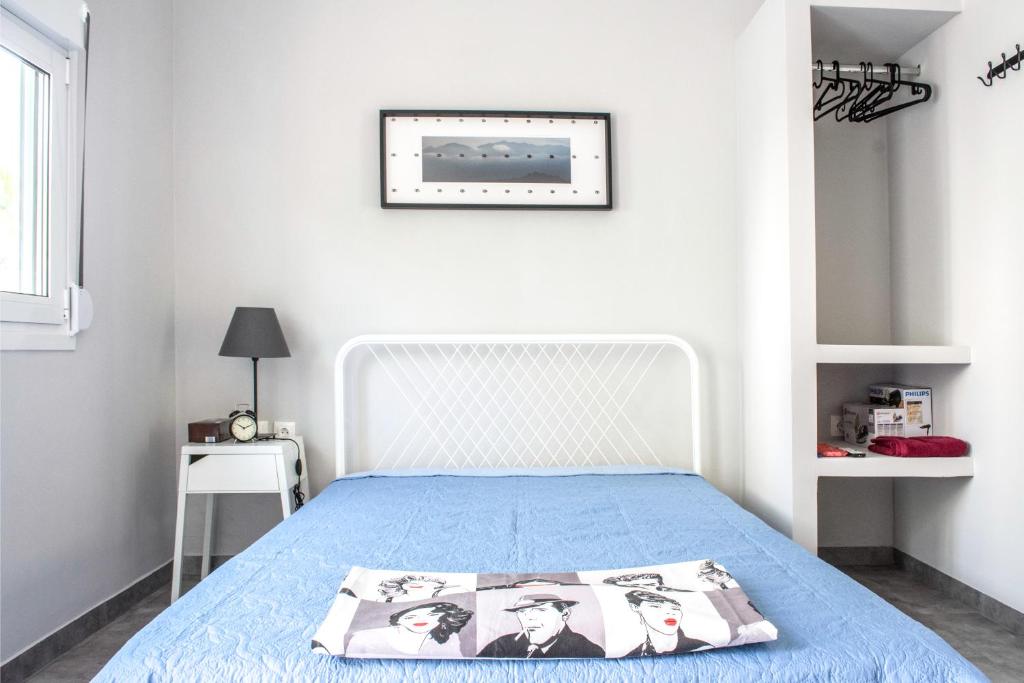 1 dormitorio con 1 cama con colcha azul en Athens 8 min from Acropolis, en Atenas