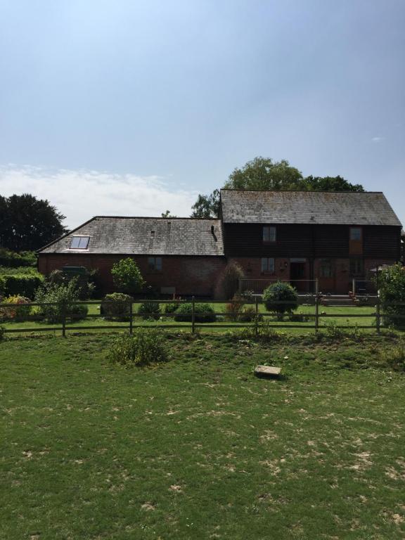 uma casa velha com um campo de relva em frente em Barons Granary em Rye