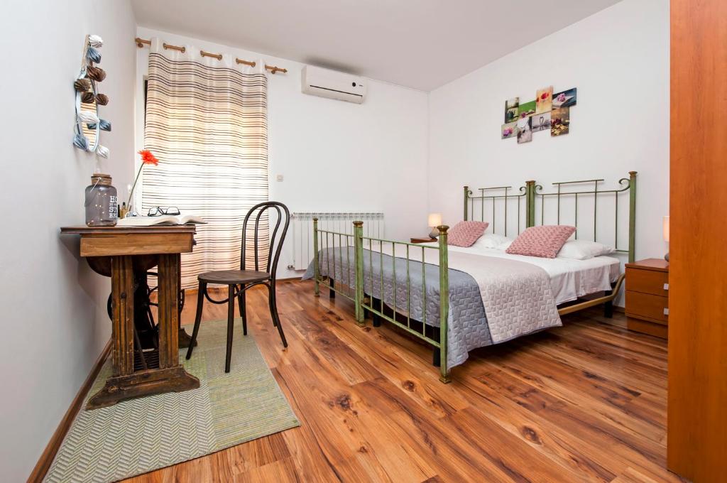 una camera con letto, scrivania e tavolo di Apartman Lamanova a Rovigno (Rovinj)