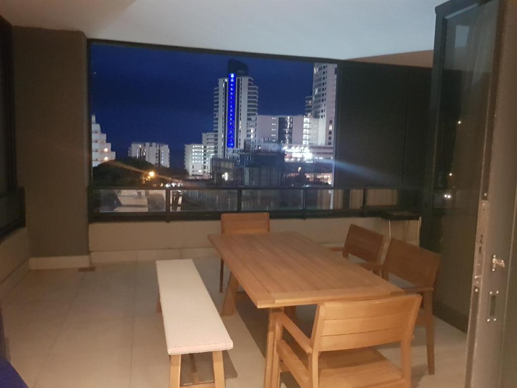 a table and chairs in front of a window with a city skyline at 126 Beacon Rock in Durban