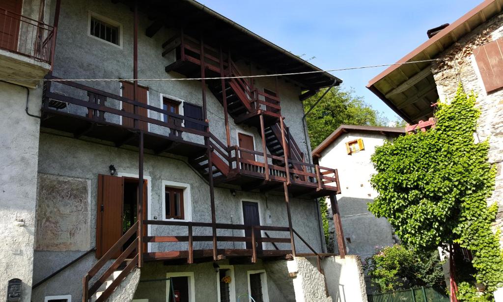 un edificio con balcones de madera en un lateral en Casa Ronit, en Delebio