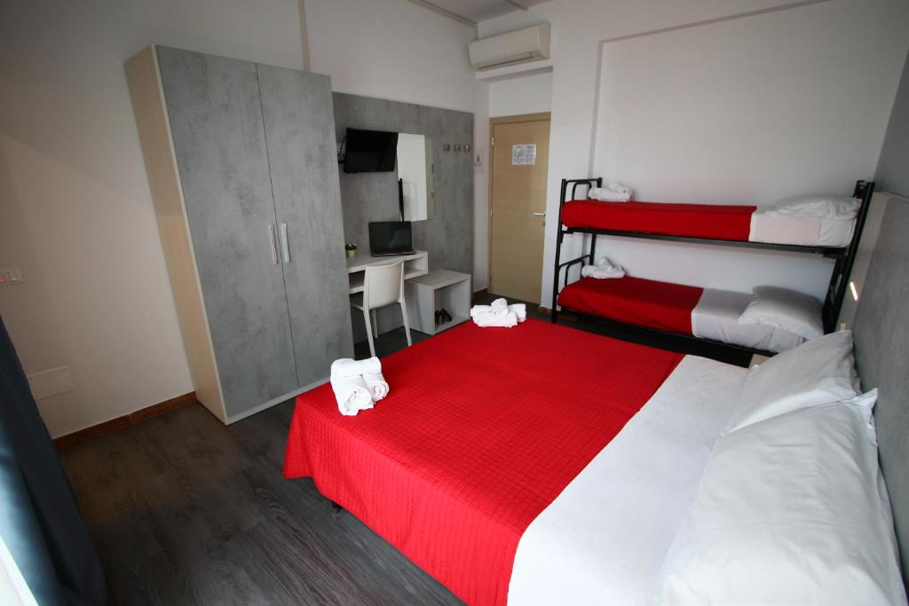 una camera da letto con un grande letto con una coperta rossa di Hotel Kim a Rimini