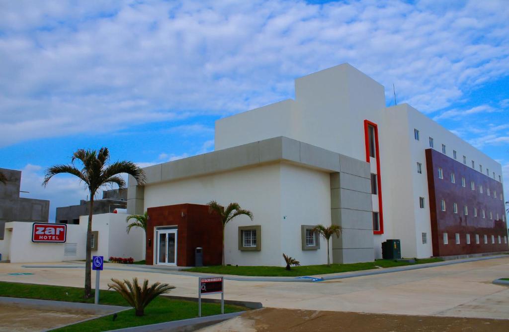 un gran edificio blanco con un letrero rojo. en Zar Coatzacoalcos, en Coatzacoalcos