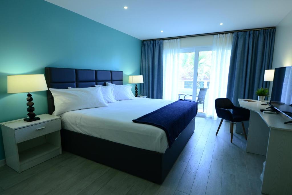 a bedroom with a large bed and a desk with a computer at Quints Travelers Inn in Willemstad