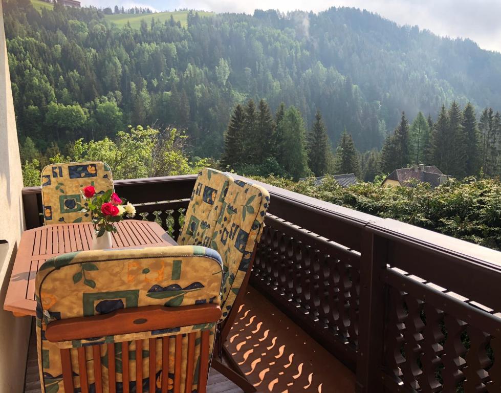 a table and chairs on a balcony with a view of a mountain at Urlaub im Zirbenland in Obdach