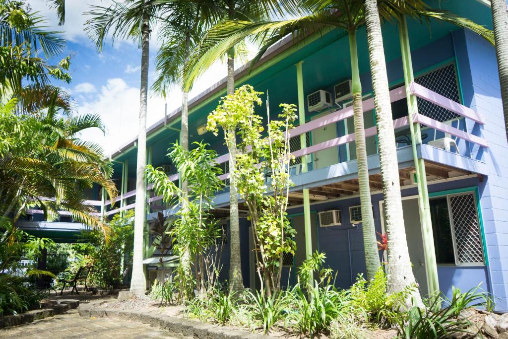 a building with palm trees in front of it at Caravella Backpackers in Cairns