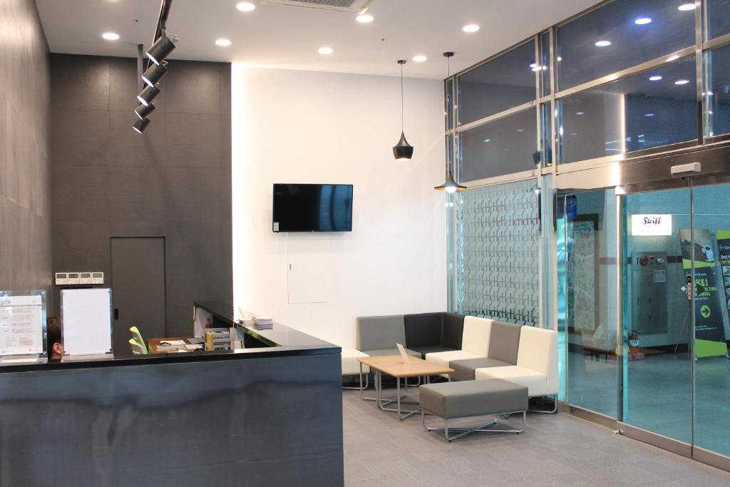 an office lobby with a reception desk and a tv at Hyundai Residence in Seoul