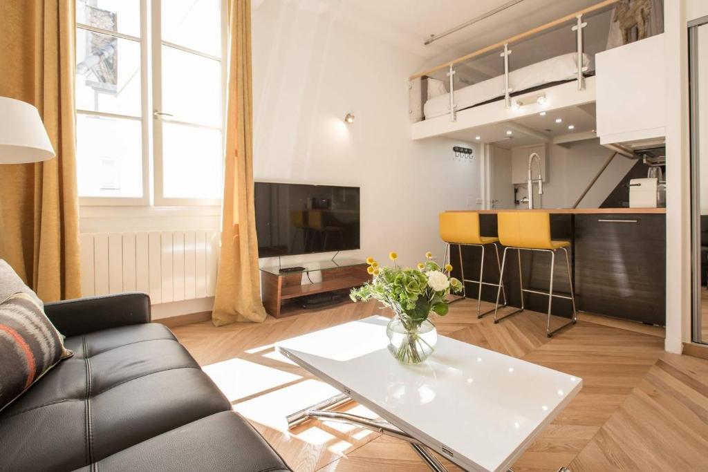 パリにあるRemodeled Parisian Apartmentのリビングルーム(ソファ、テーブル付)