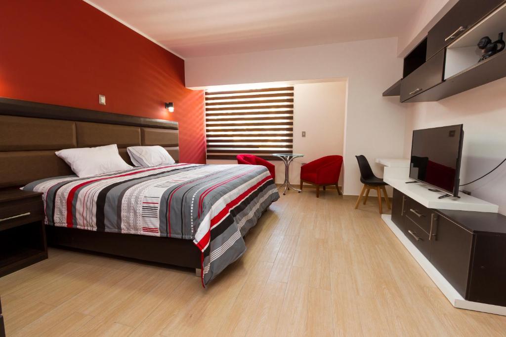 a bedroom with a bed and a desk and a television at Hotel Turin in Tarma
