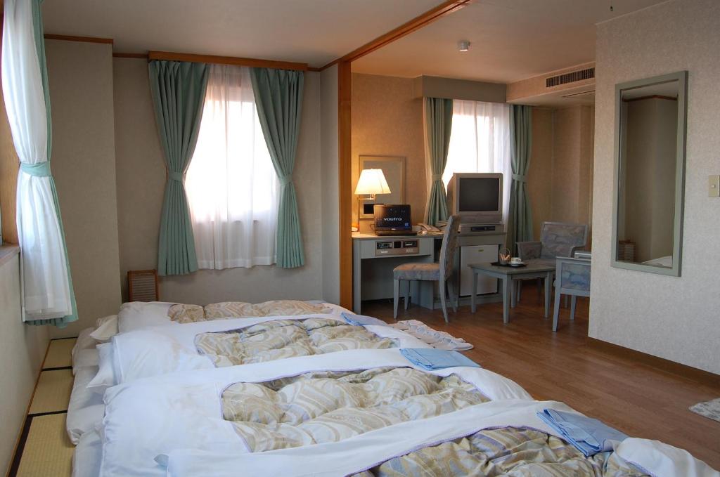 Postel nebo postele na pokoji v ubytování Seagrande Shimizu Station Hotel