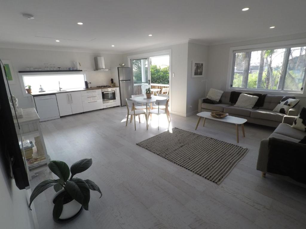 a living room with a couch and a table at Lautan Cronulla Beach in Cronulla