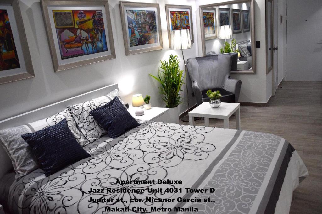 a bedroom with a bed and a couch and a chair at Jazz Makati Luxury Apartment in Manila