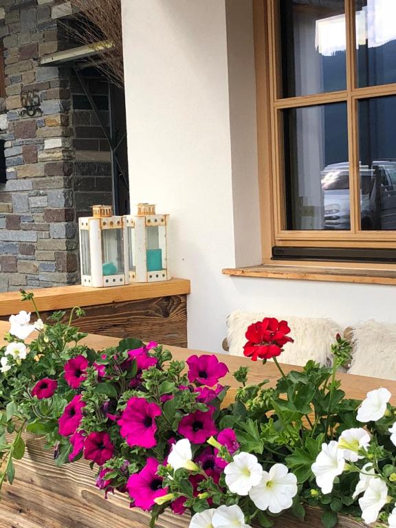 einen Tisch mit rosa und weißen Blumen drauf in der Unterkunft Alpbach 646 in Alpbach