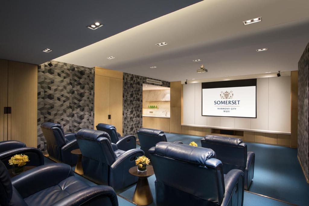 a waiting room with blue chairs and a projection screen at Somerset Harmony City Wuxi in Wuxi