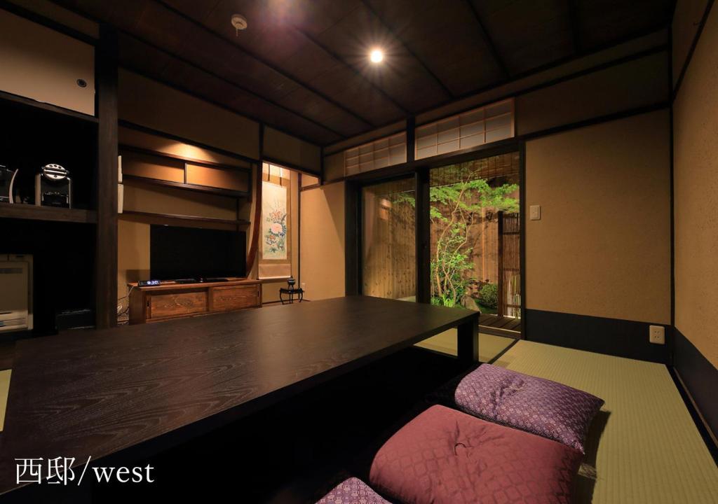 uma sala de jantar com uma mesa grande e uma cadeira rosa em Houka em Quioto