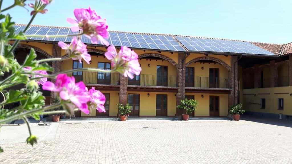 un edificio con un montón de flores púrpuras delante de él en Agriturismo Cascina del Peso, en Leinì