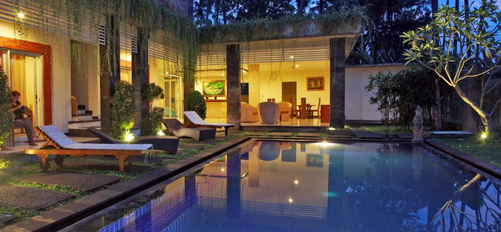 een huis met een zwembad in de tuin bij Long Lane Bali Villa in Ubud