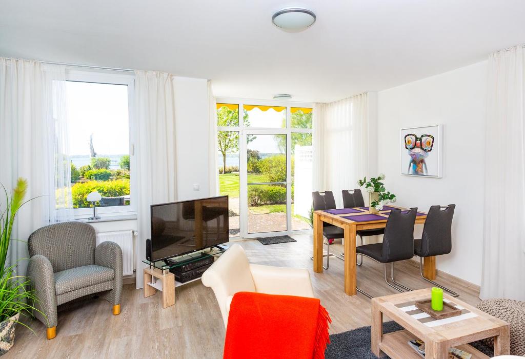 sala de estar con TV, mesa y sillas en Ferienresidenz "Seelust" Whg 5 en Waren