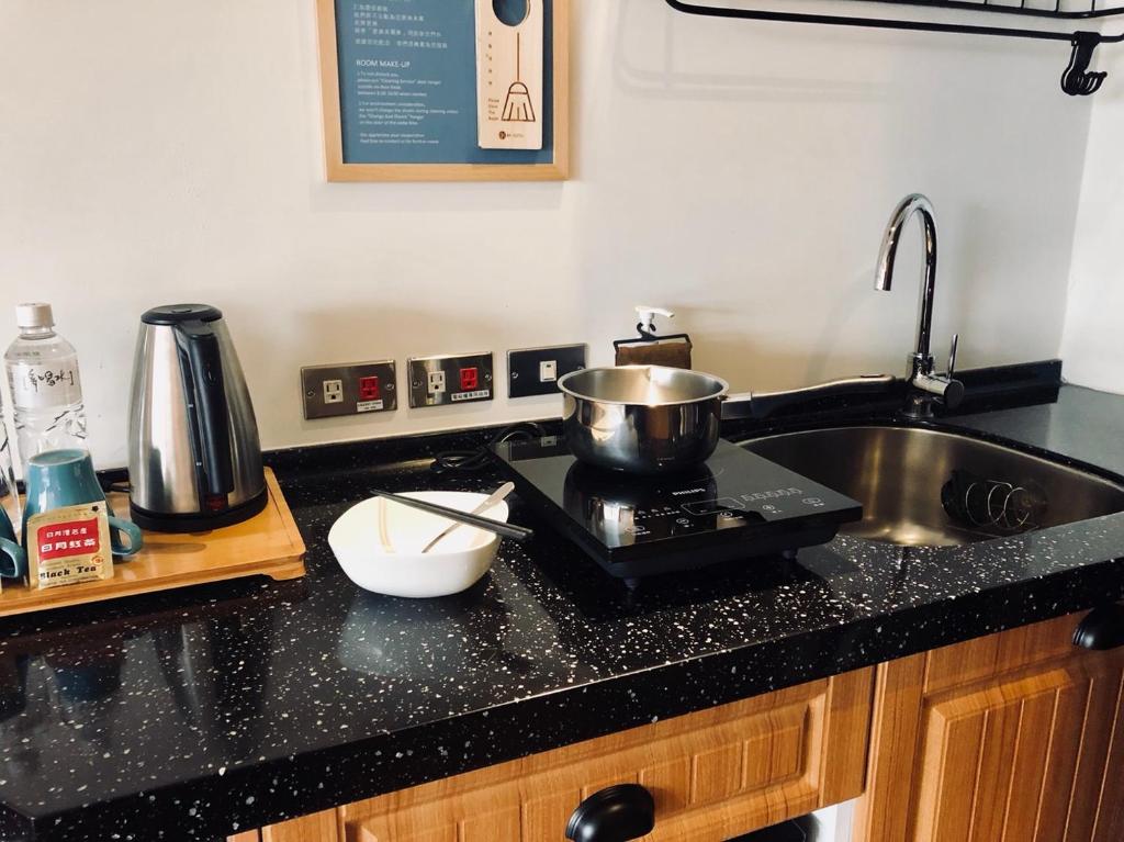 a kitchen counter with a sink and a pot on a stove at NK Hostel in Taipei