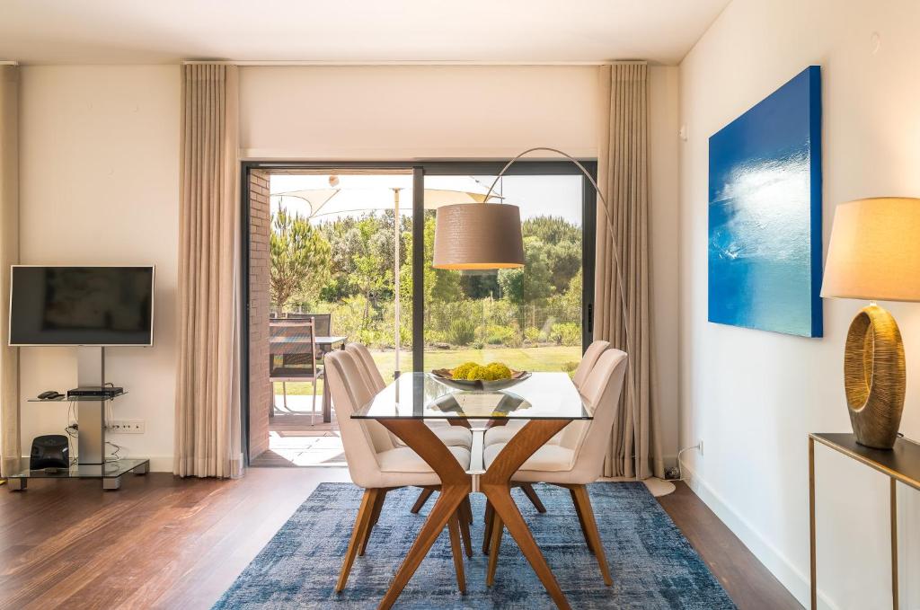 a dining room with a table and chairs and a television at Vilamoura Charming Apartment by Intiholidays in Vilamoura