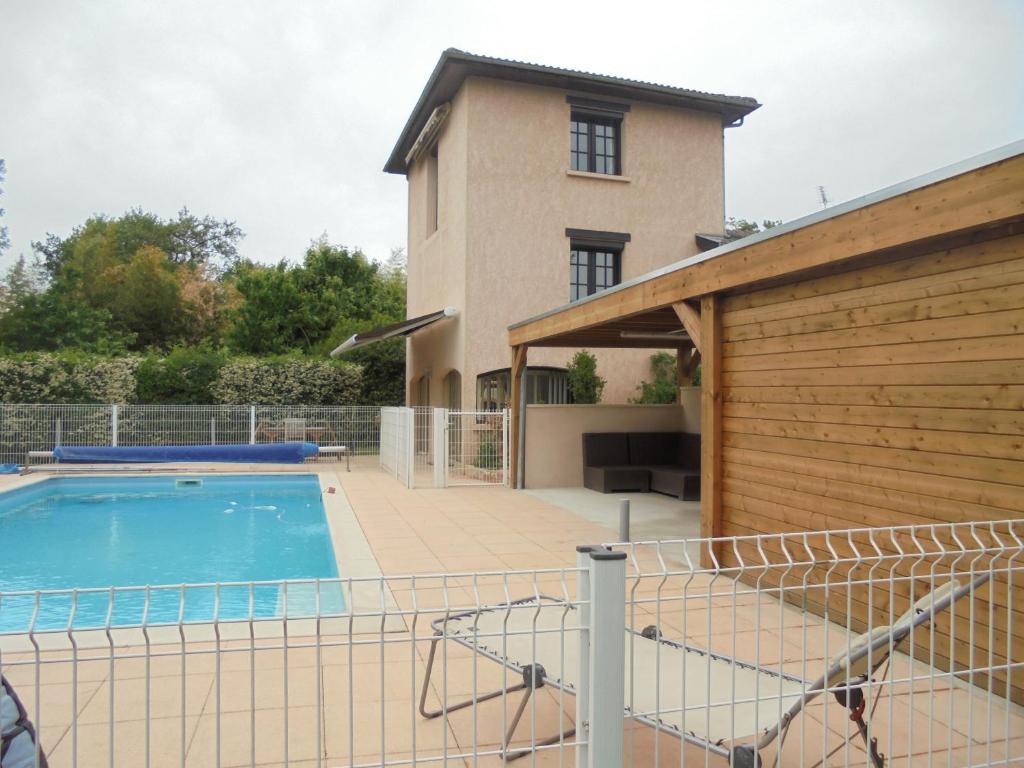 a villa with a swimming pool in front of a house at Gites de Frans in Frans