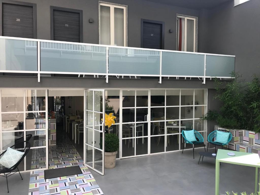 a building with glass doors and blue chairs at Albergo Del Pino in Cercola