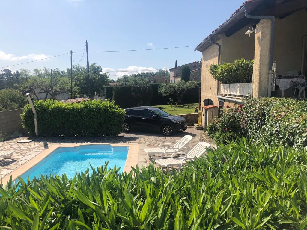 un'auto parcheggiata accanto a una casa con piscina di Mas de Pascalette a Montauroux