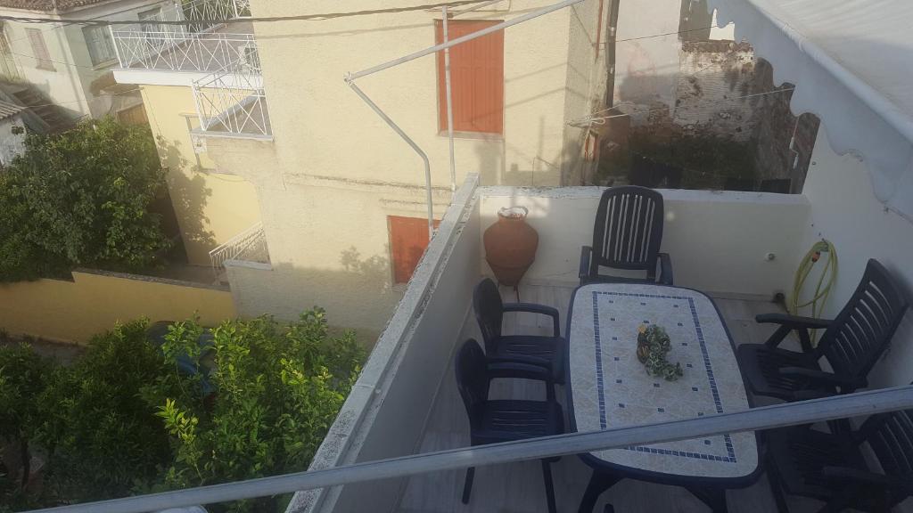 a balcony with chairs and a table and a building at P & G Apartment in Pámfylla