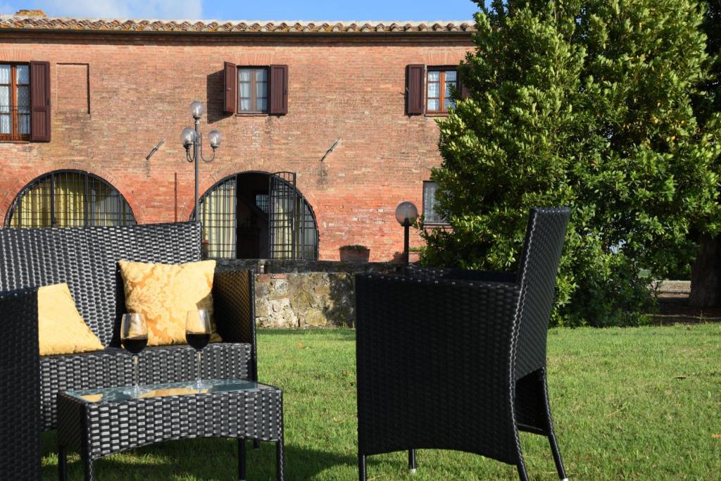 シエナにあるPodere il Granaio - Crete Senesi - Tuscanyの建物前の椅子2脚とソファ