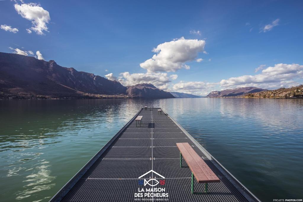 a dock in the middle of a body of water at La maison des pêcheurs in Viviers-du-Lac