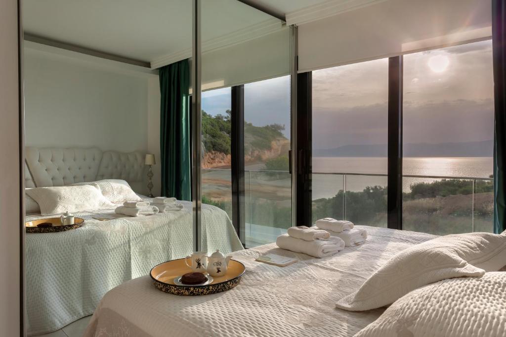 a bedroom with two beds and a large glass window at Sato Design Hotel in Çeşme