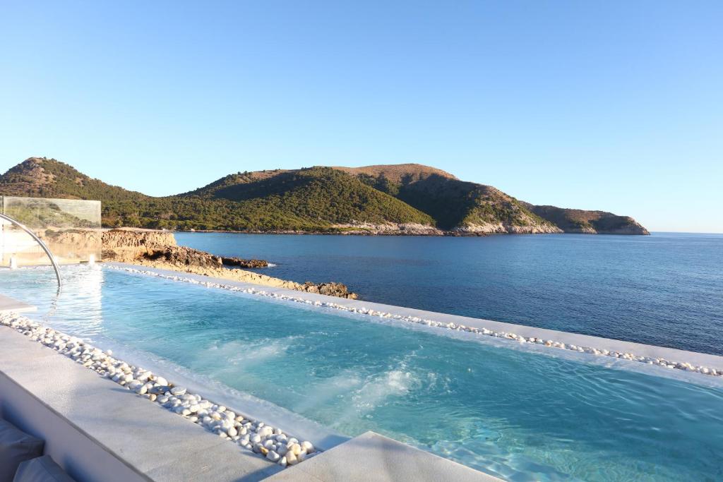 a swimming pool with a view of the ocean at Mar Azul Pur Estil Hotel & Spa in Cala Ratjada