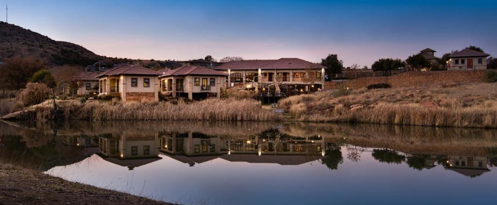 a group of houses next to a body of water at Heidelberg Kloof Lodge in Heidelberg