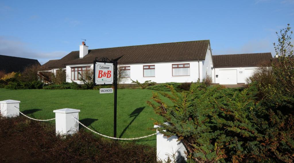 una casa con una señal de límite de velocidad en un patio en Cottesmore Bed and Breakfast, en Bushmills