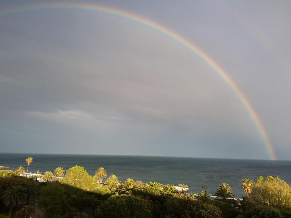 een regenboog in de lucht boven de oceaan bij Skyline, Casa Vacanze in Savona