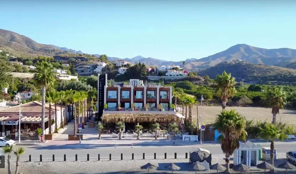 a view of a town with palm trees and a building at H Boutique Peña Parda in La Herradura